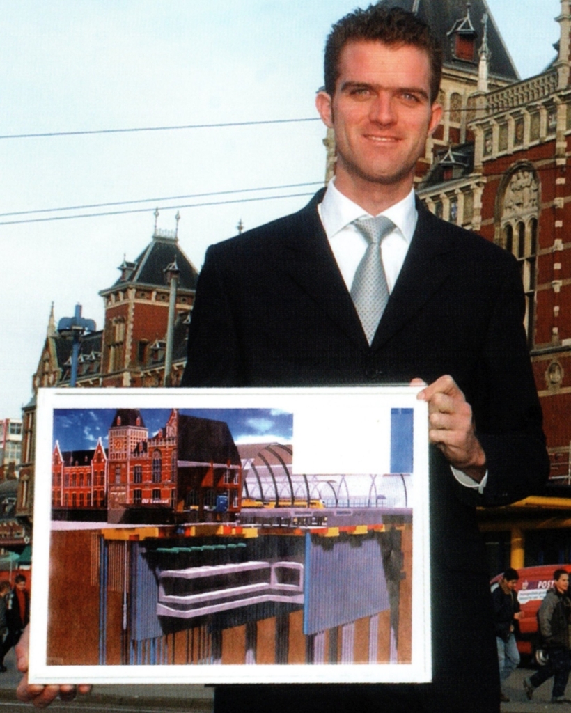 Robert in 2002 voor station Amsterdam Centraal met artist impressie van Noordzuidlijn